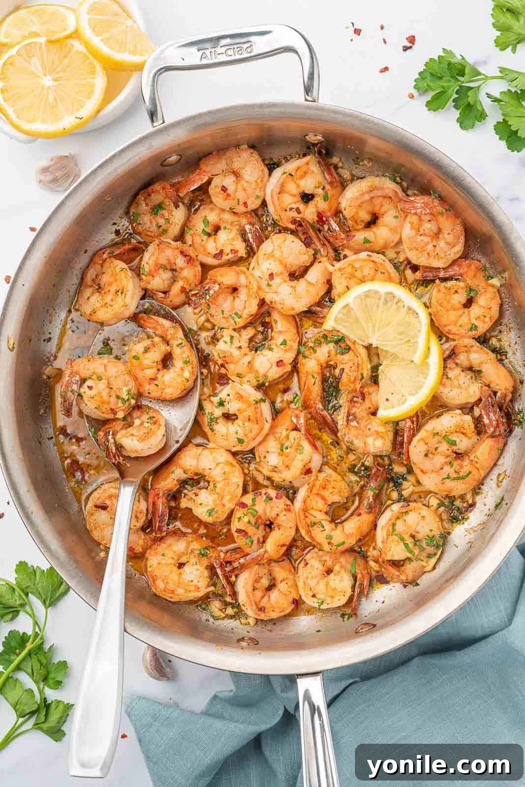 Bright and Buttery Lemon Garlic Shrimp 2 A skillet of perfectly cooked garlic and lemon shrimp, garnished with fresh parsley and lemon slices.