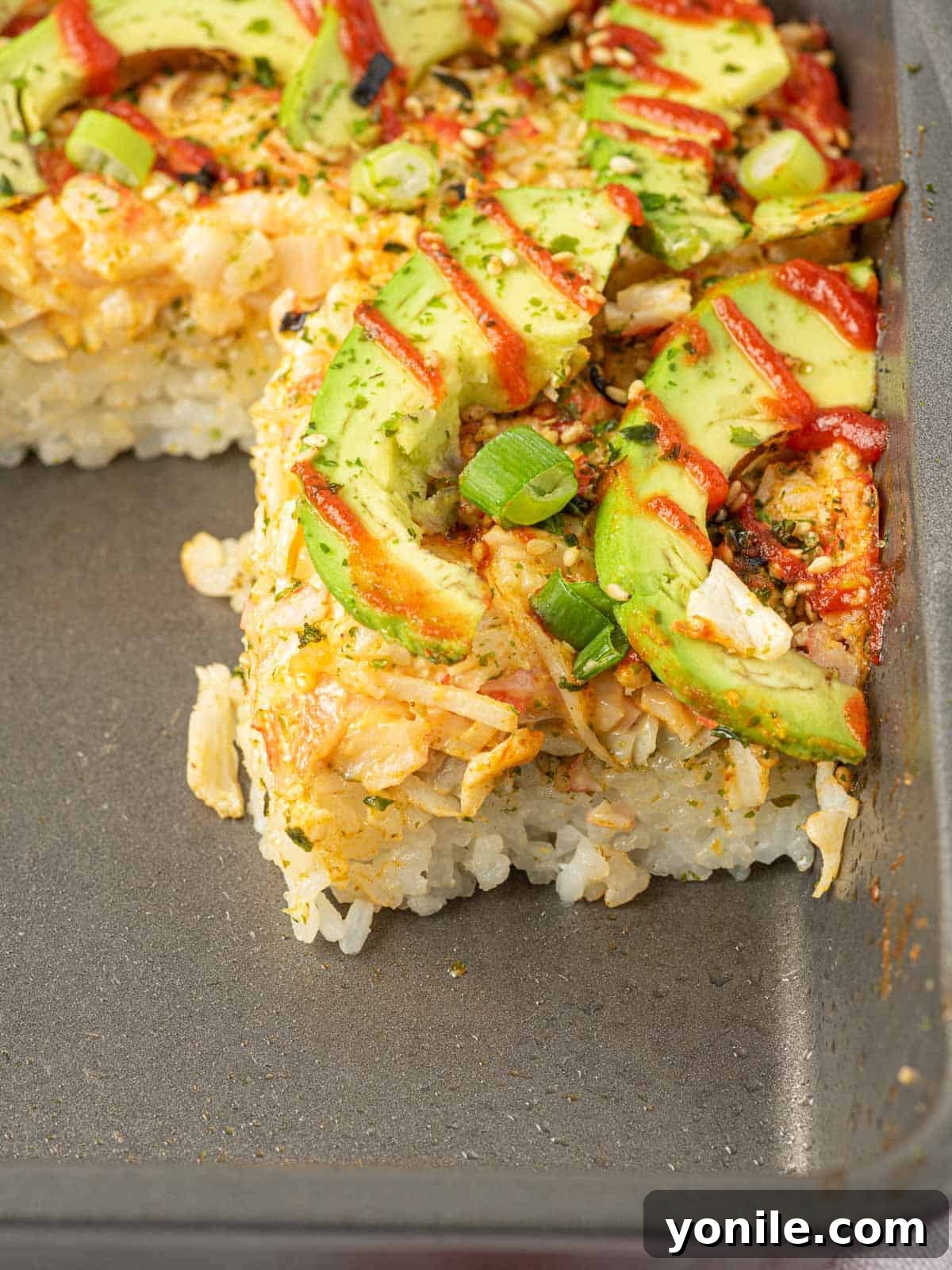 Effortless Baked Sushi 8 Imitation crab sushi bake in a casserole dish, garnished and ready to serve.