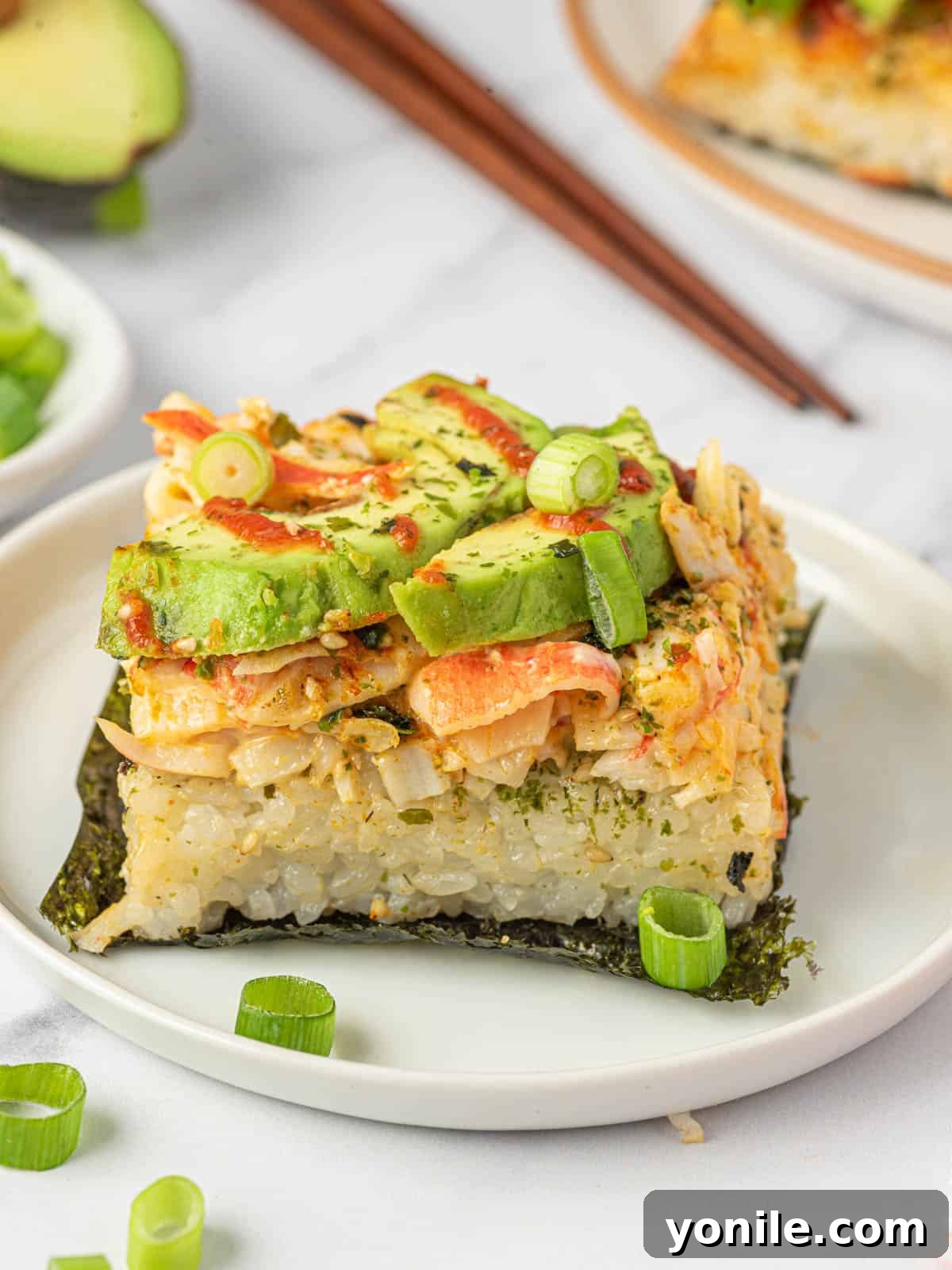 Effortless Baked Sushi 10 A single piece of sushi bake resting on a nori square on a plate.
