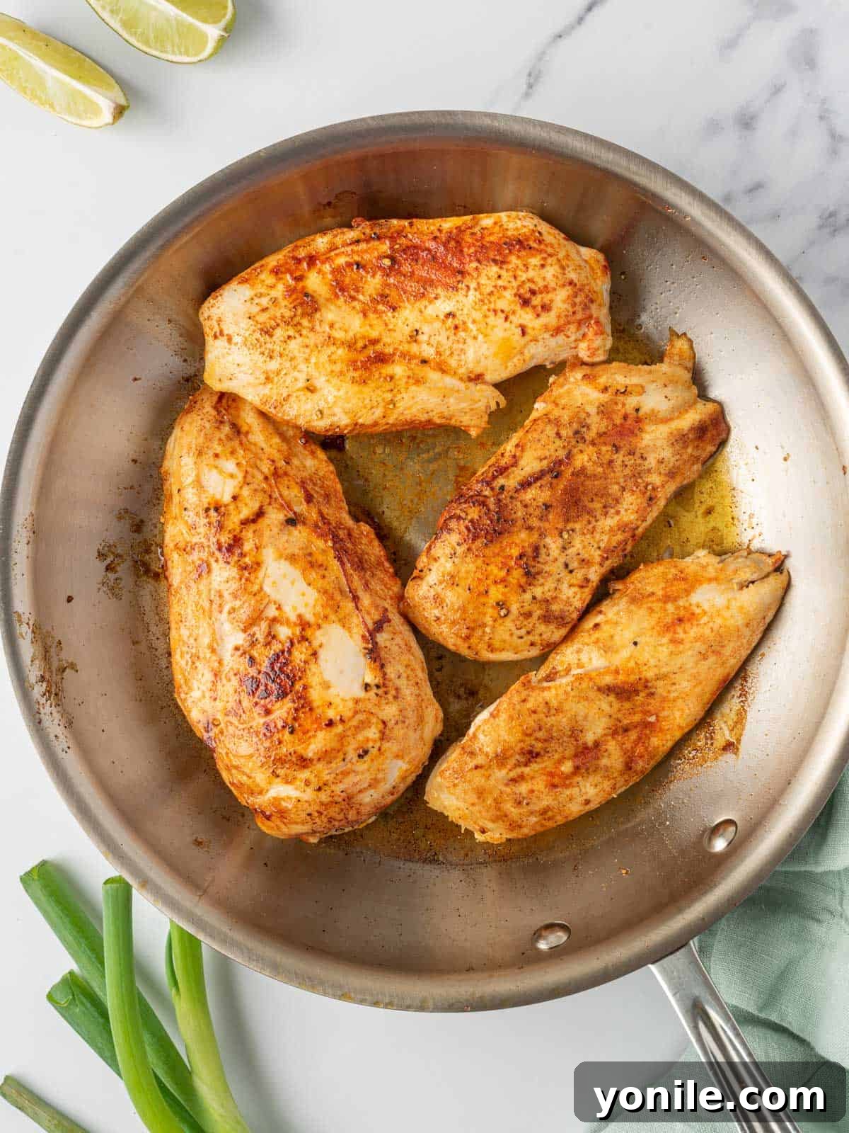 Searing the spicy chicken breast recipe in a skillet to achieve a golden crust.