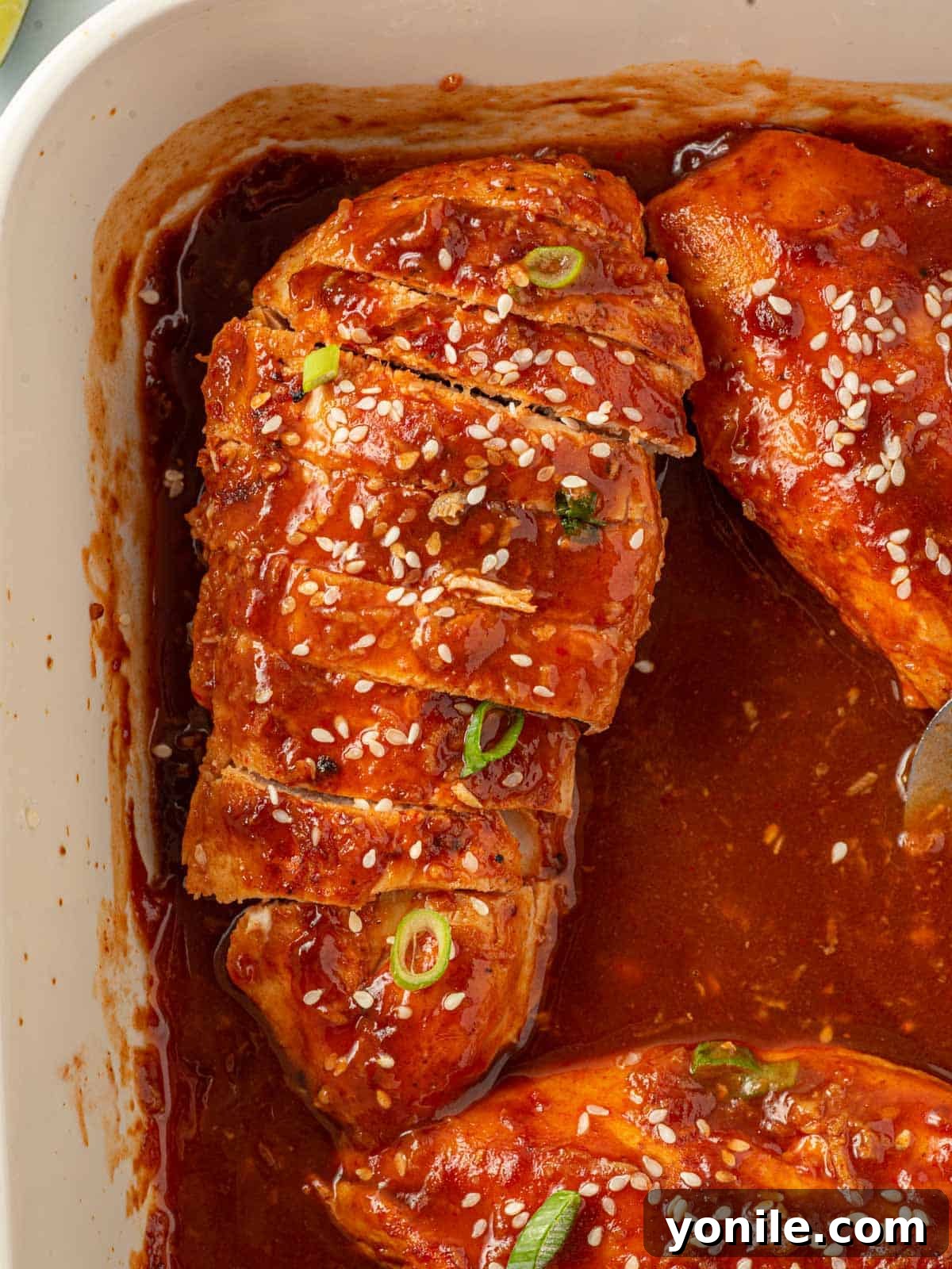 Spicy chicken breast recipe sliced in a pan for serving, showing its juicy interior.