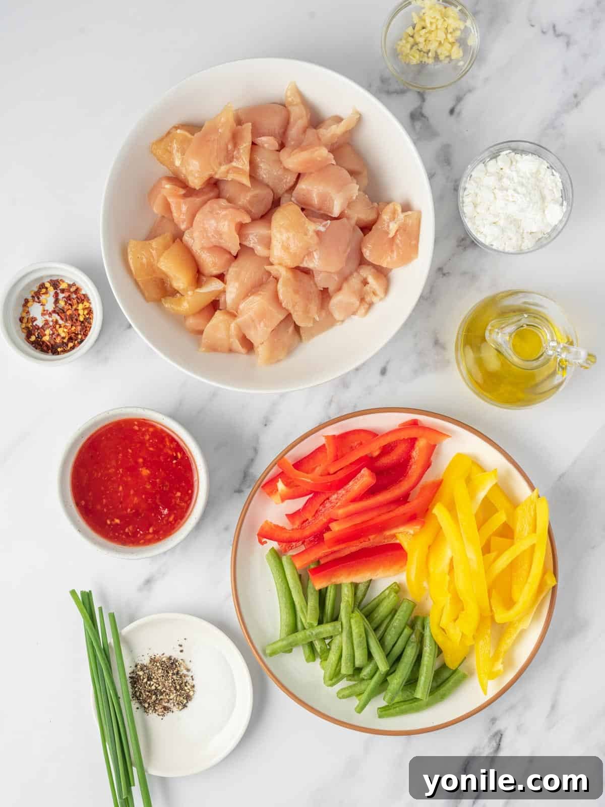 All the fresh ingredients meticulously laid out for preparing a delicious sweet Thai chili chicken stir fry.