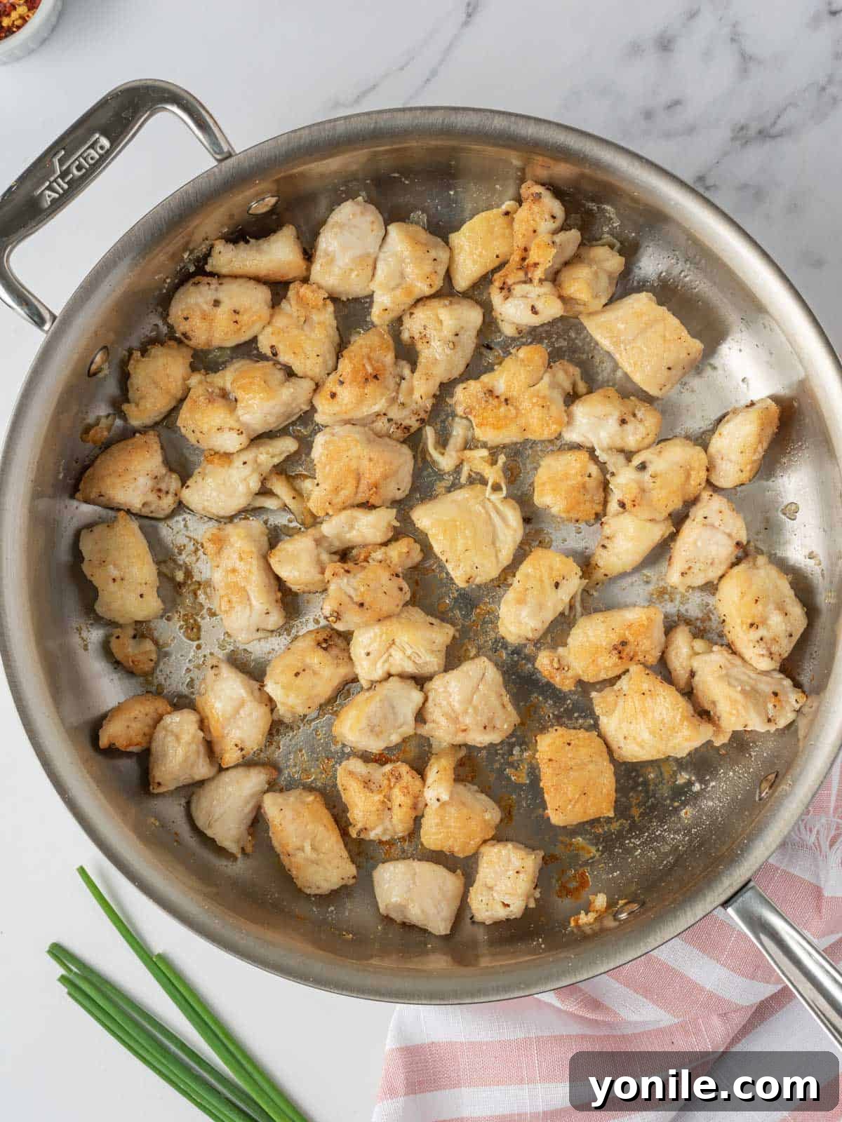 Golden-brown, crispy chicken pieces sizzling in a deep skillet, ready to be stir-fried.