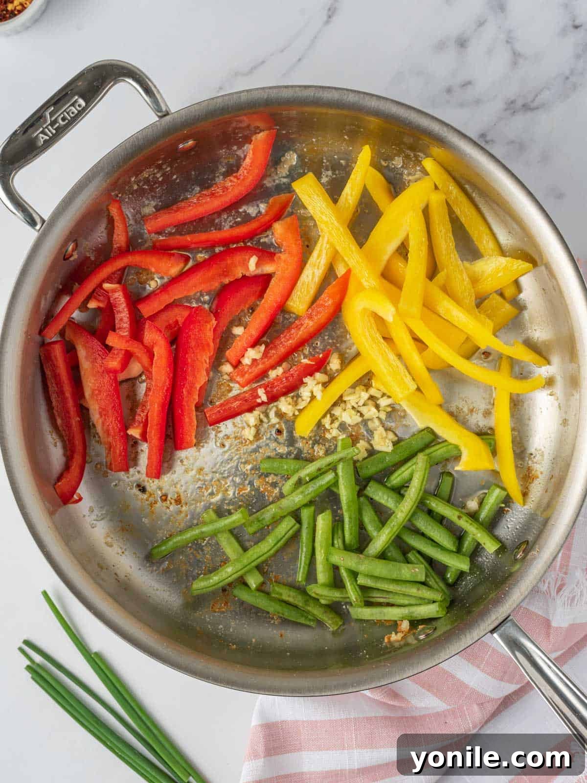 Vibrant bell peppers and fresh green beans sautéing in a hot skillet, becoming tender-crisp for the stir fry.