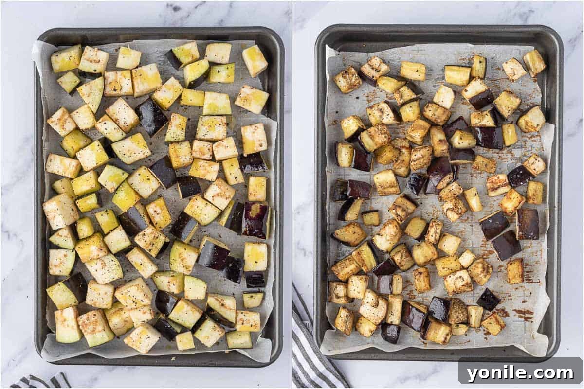 Cubed eggplant pieces tossed with olive oil, salt, and pepper on a parchment-lined baking sheet.