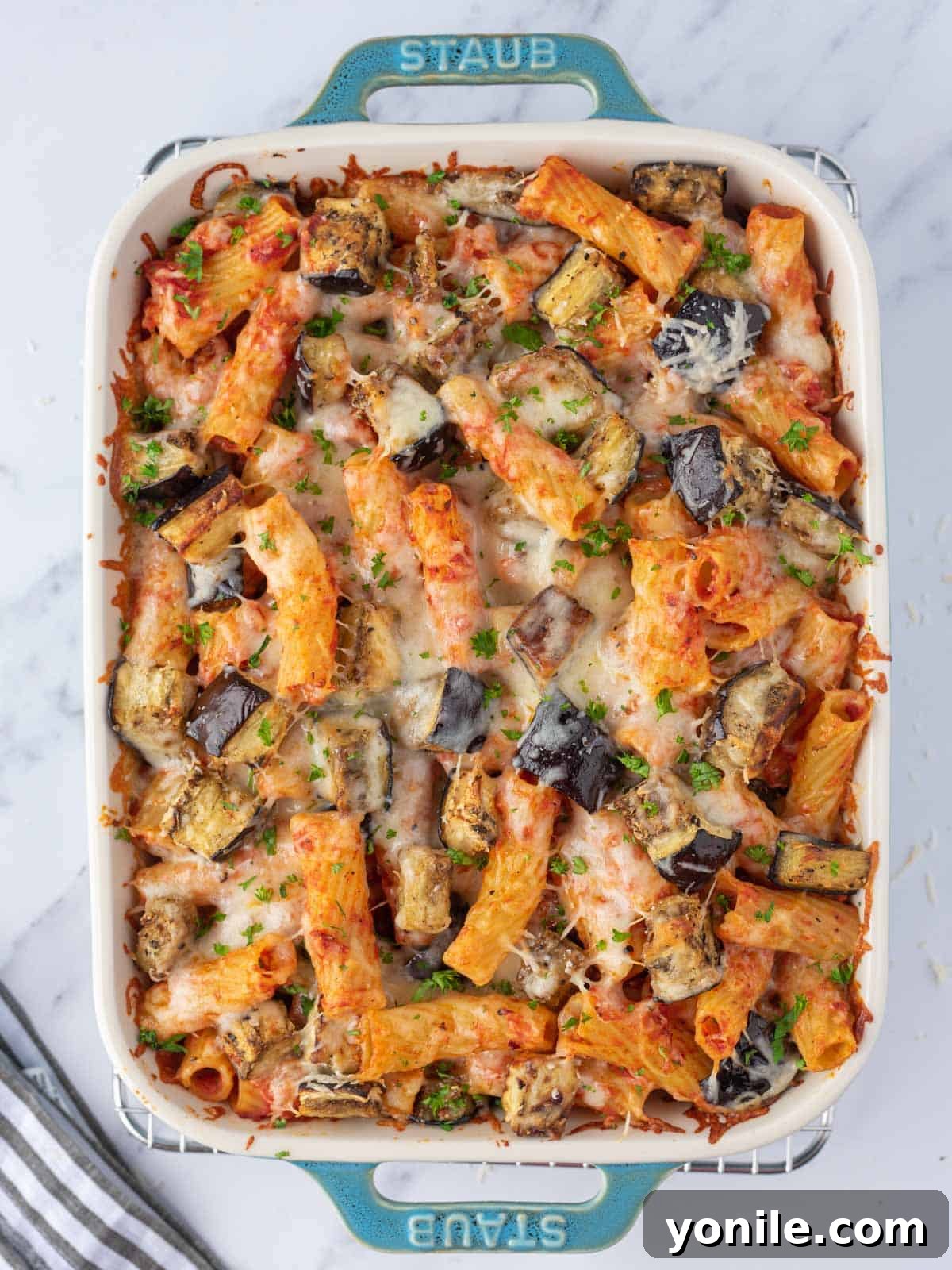 Close-up top view of a bubbly, golden-brown baked eggplant casserole.