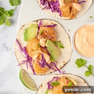 Quickfire Dynamite Shrimp Tacos 11 Three bang bang shrimp tacos with dynamite sauce sit on a serving platter.