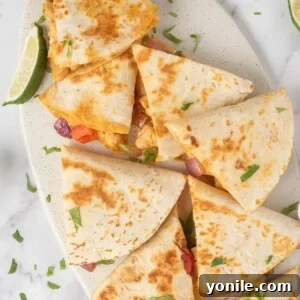 A platter of fajita quesadillas with a lime wedge.