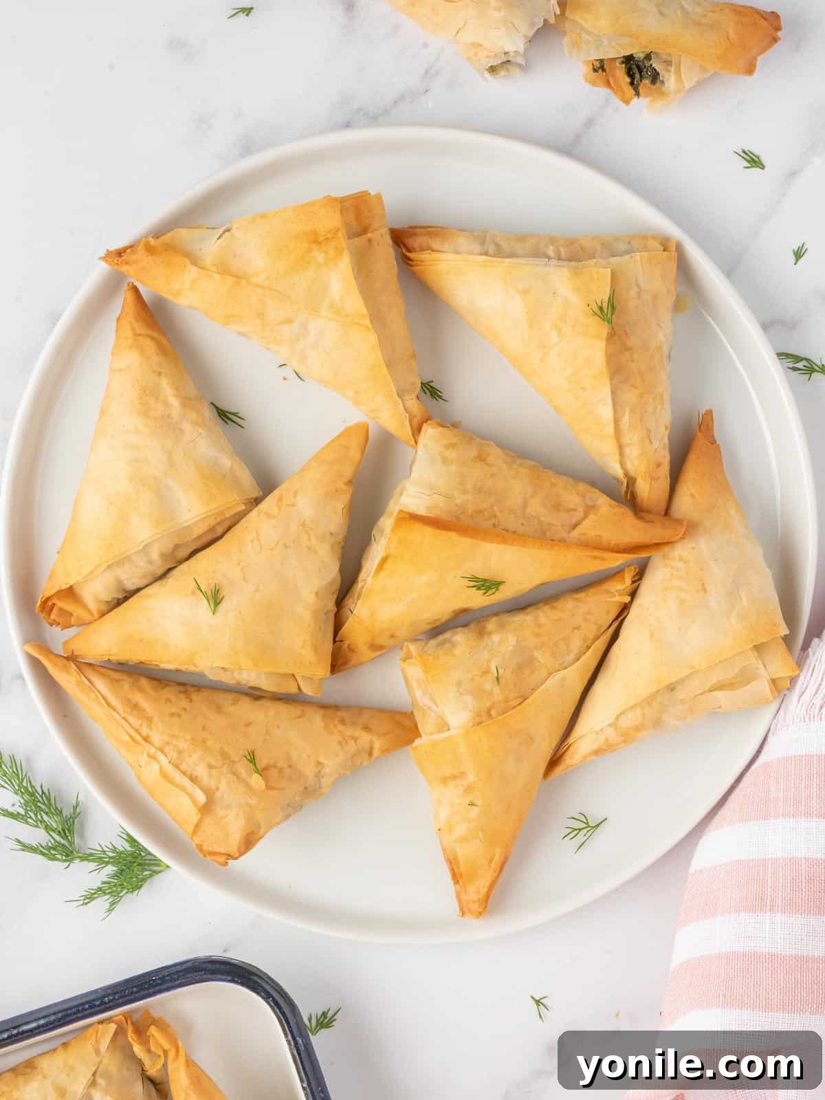 Simple Spanakopita Bites 8 A vibrant platter of freshly baked spinach and feta triangles, ready for serving.