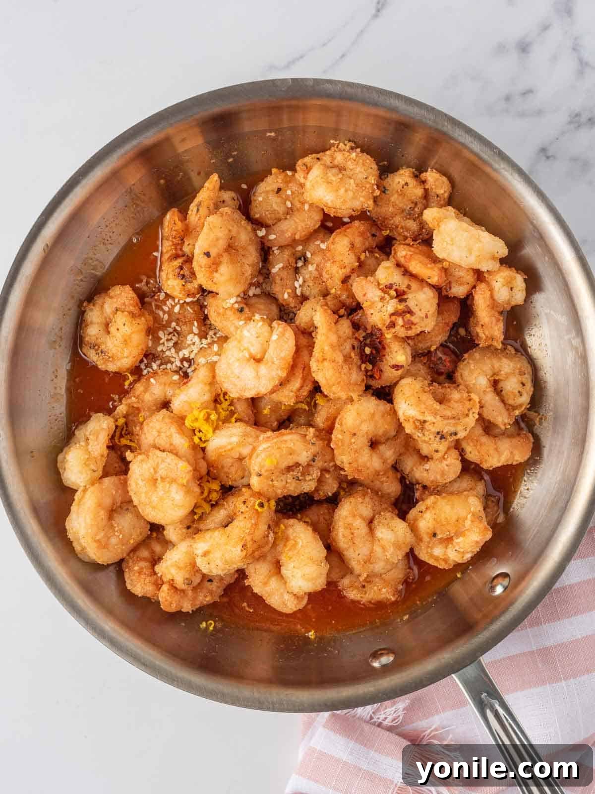 Dynamite Prawns 7 Tossing spicy fried shrimp with firecracker shrimp sauce in a pan.