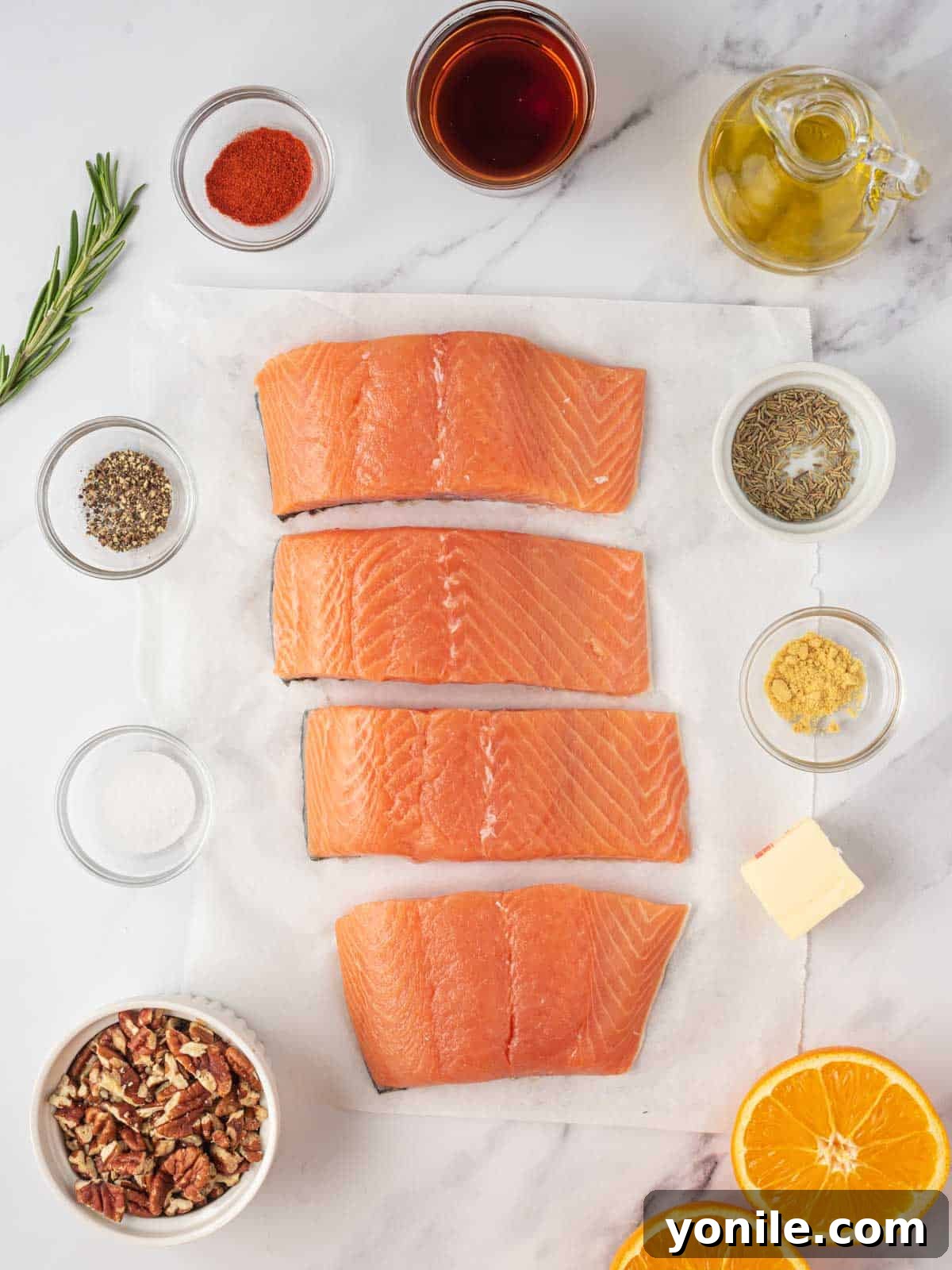 Ingredients for maple pecan glazed salmon including salmon fillets, pecans, maple syrup, and spices.