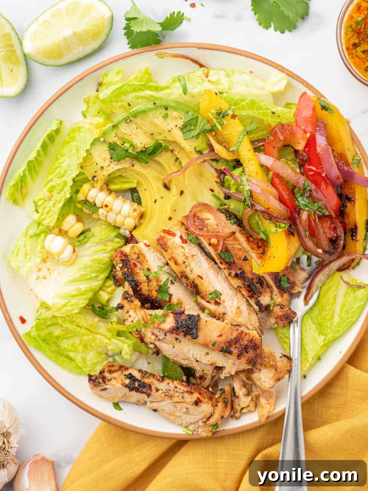 Chicken fajita salad on a plate with a fork.