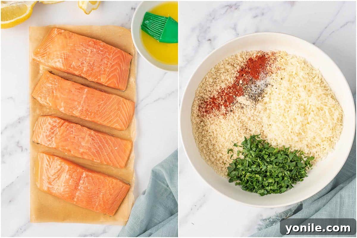 A cook's hands are preparing salmon fillets, brushing them with melted butter, with a bowl of parmesan and panko mixture ready for coating in the background.