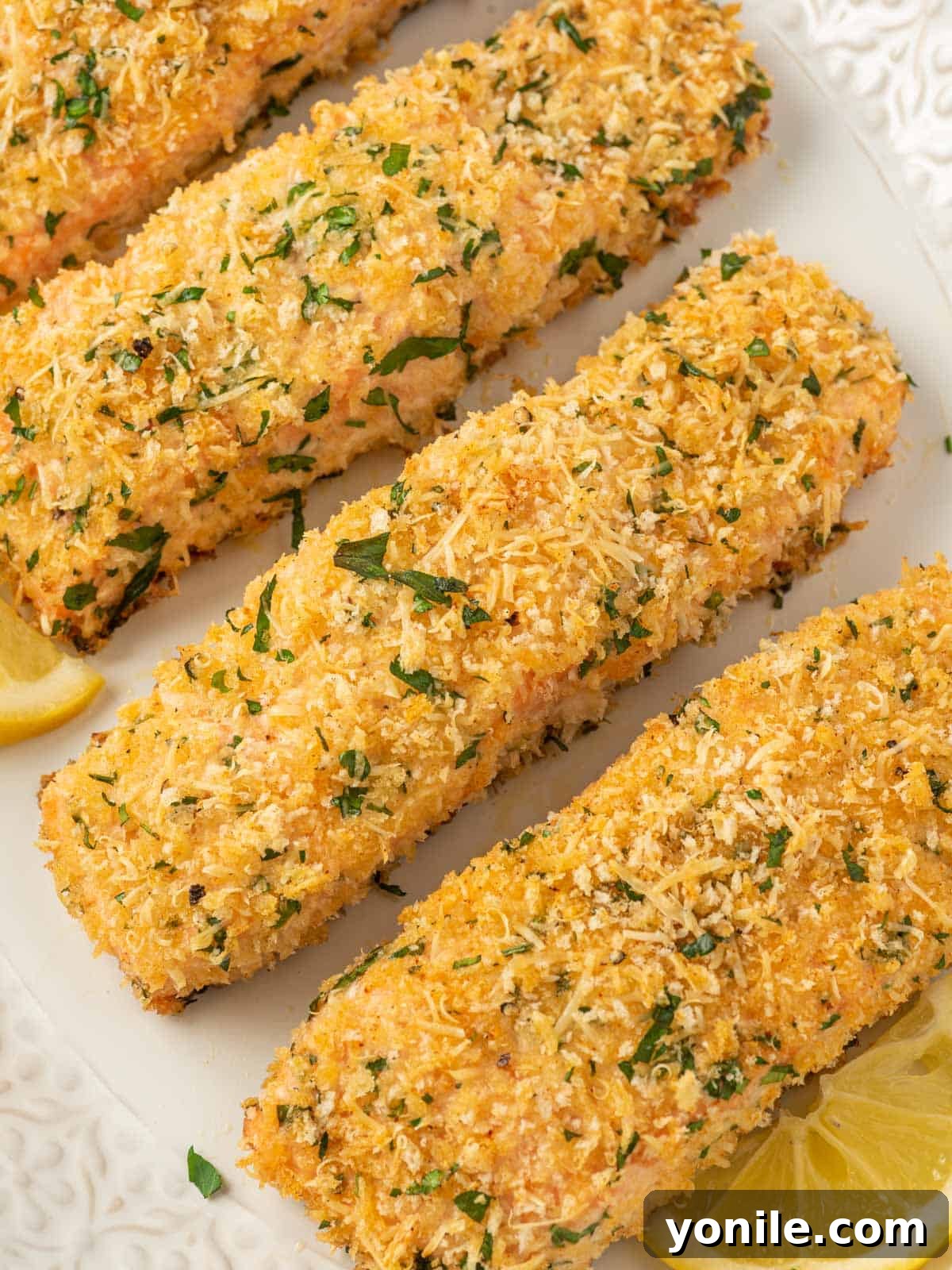 Close-up view of a perfectly baked parmesan crusted salmon fillet, showing its golden, crispy crust and tender texture.
