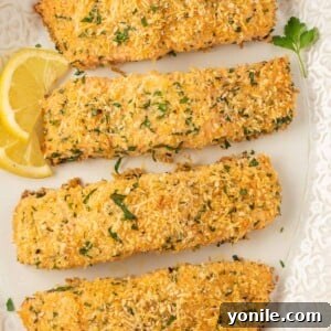 Crispy baked salmon fillets on a platter with lemon slices.