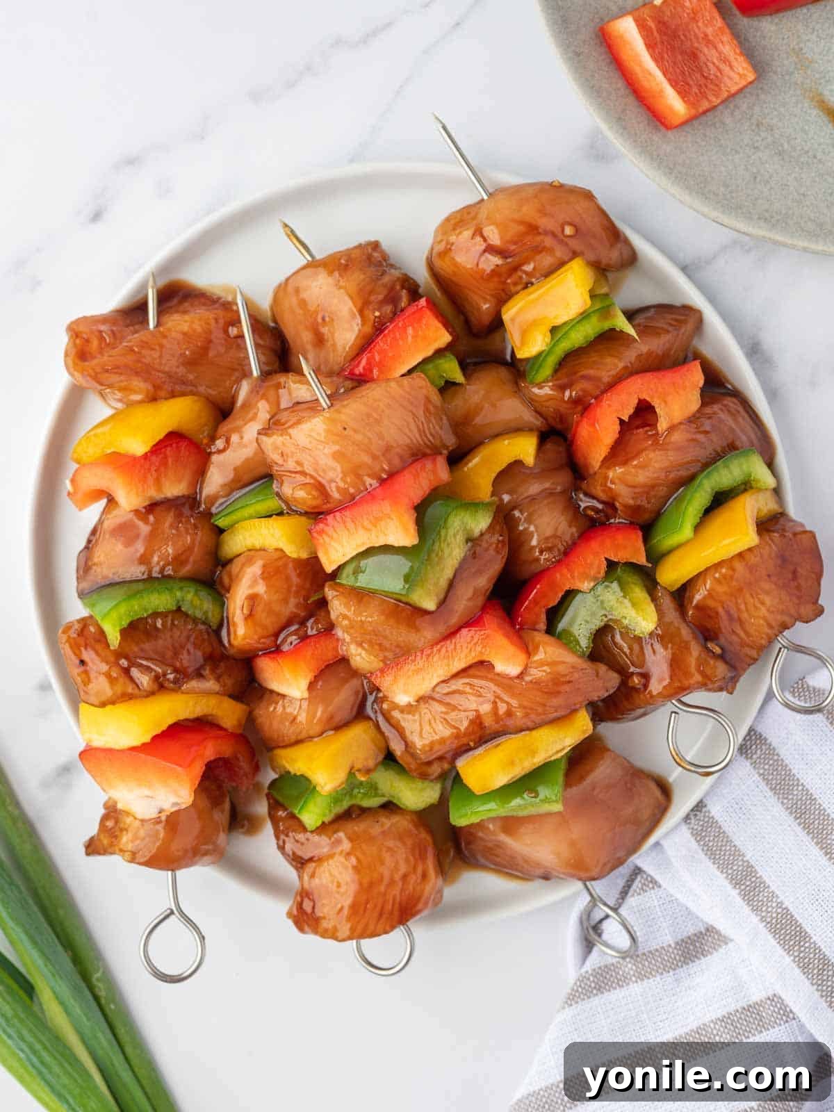 Teriyaki Glazed Chicken Skewers 6 Marinated teriyaki chicken and bell peppers threaded onto skewers, ready for grilling.
