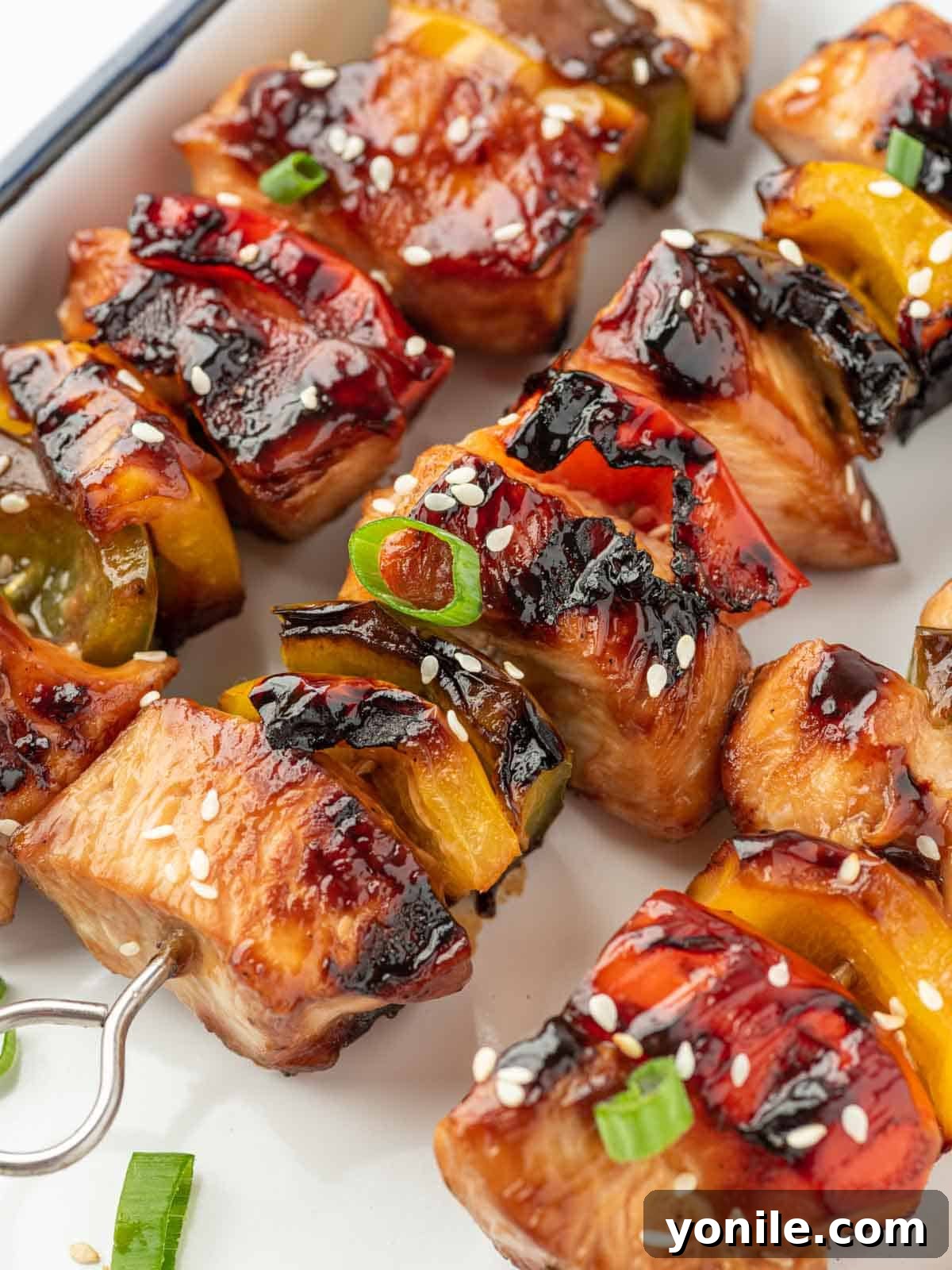 Teriyaki Glazed Chicken Skewers 9 Close-up of grilled chicken teriyaki skewers with peppers on a platter, showcasing the beautiful char.