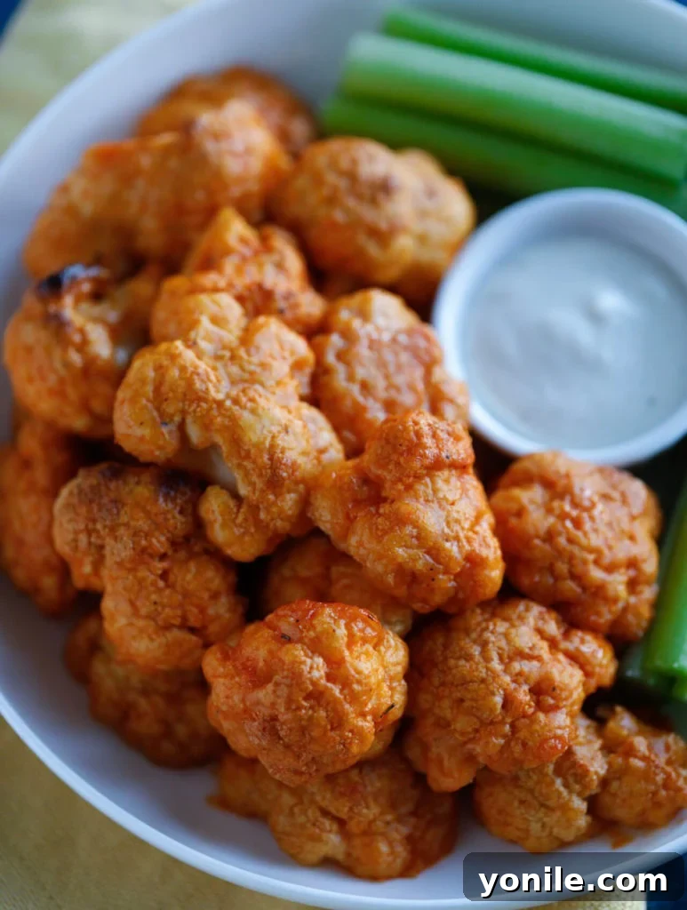 Delicious Buffalo Cauliflower Wings Ready to Serve Close-up shot of perfectly baked and sauced Buffalo Cauliflower Wings on a serving platter.