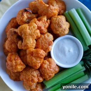 A vibrant plate of Buffalo Cauliflower Wings, served with a side of cool ranch dip.