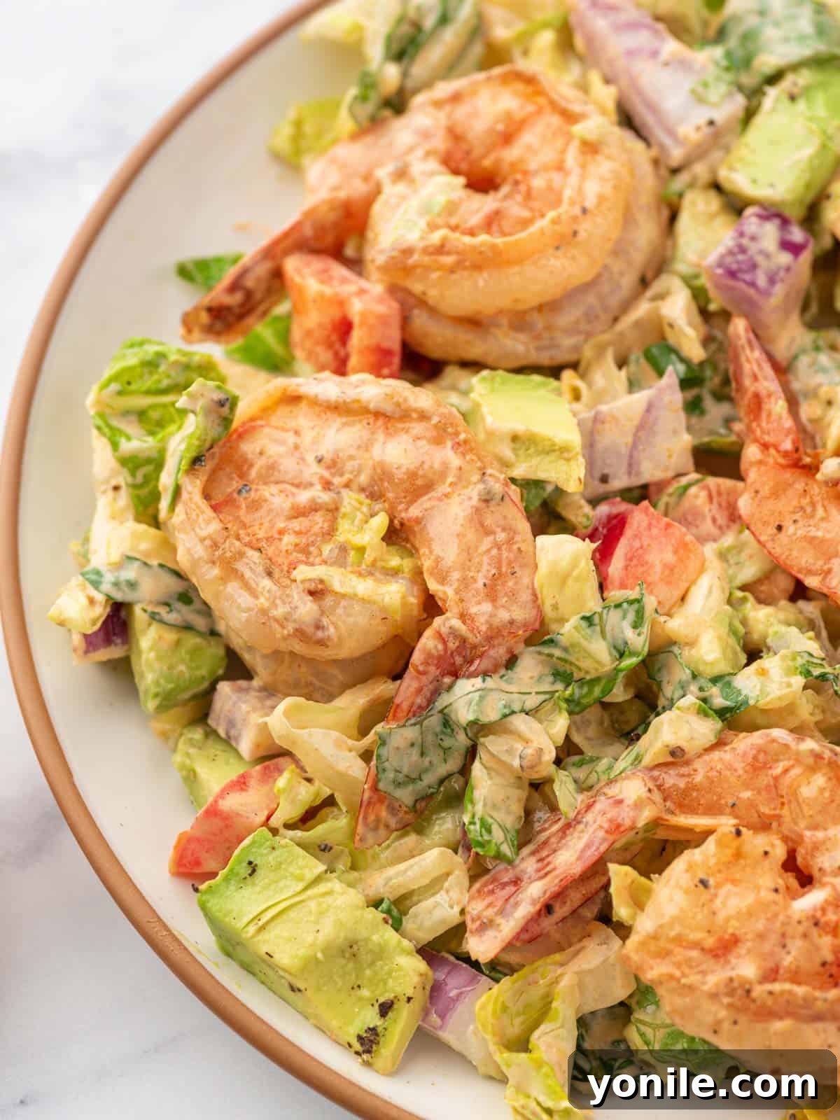 A single serving of shrimp avocado salad elegantly arranged on a plate.