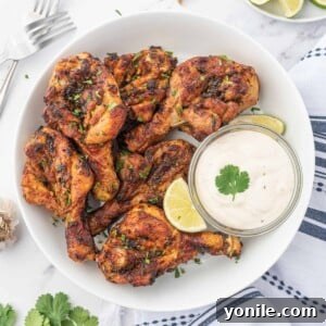 Blossoming Drumsticks 11 Air fryer butterfly chicken drumsticks on a plate with dipping sauce.