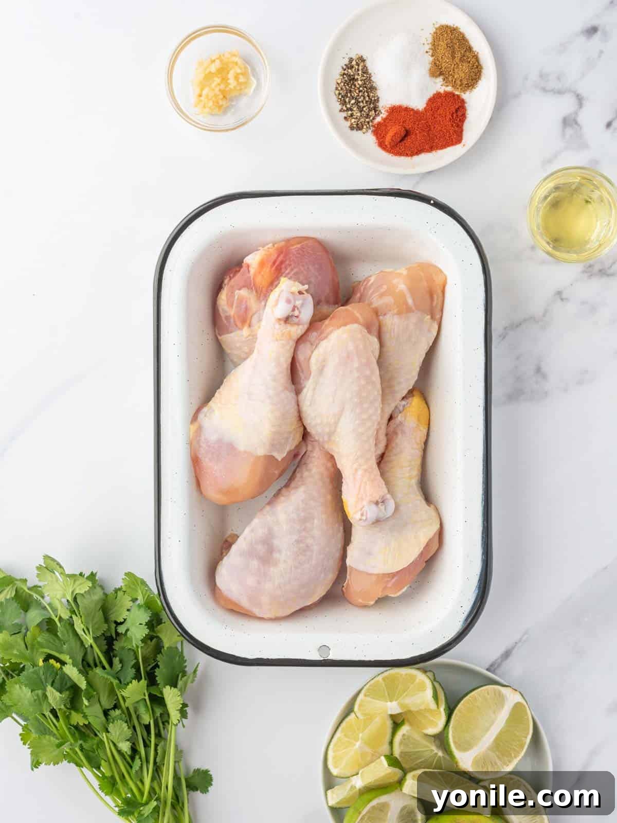 Blossoming Drumsticks 3 Fresh ingredients laid out for making cilantro lime butterfly chicken drumsticks, including lime, cilantro, garlic, and spices.
