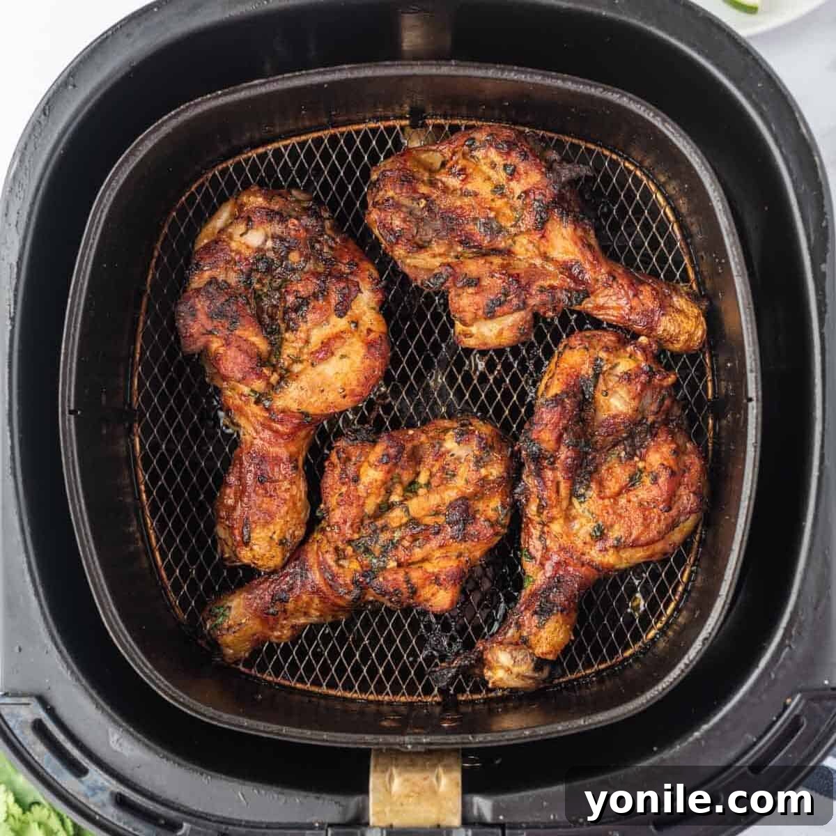 Blossoming Drumsticks 7 Butterfly drumsticks cooking in an air fryer basket, arranged in a single layer.