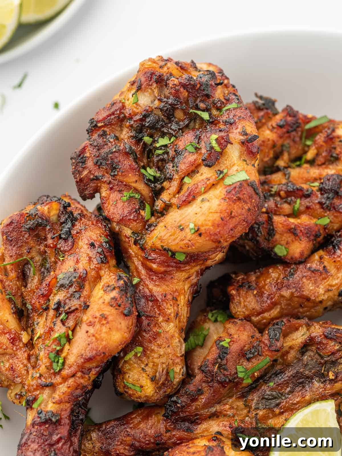 Blossoming Drumsticks 8 Close-up of perfectly air-fried butterfly chicken drumsticks, garnished with fresh cilantro and ready to serve.