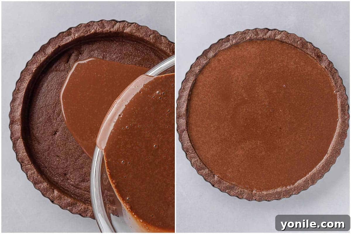 Pouring the smooth vegan chocolate pie filling into the prepared no-bake crust in a tart pan.