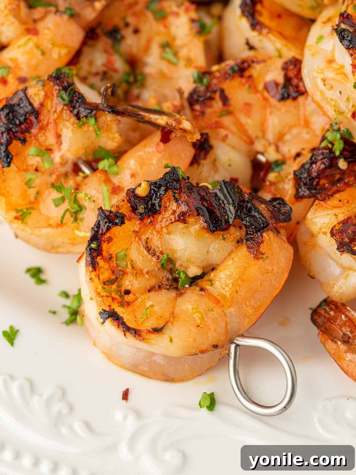 Closeup of zesty grilled garlic shrimp skewers, showing off the marinade and perfect cook.