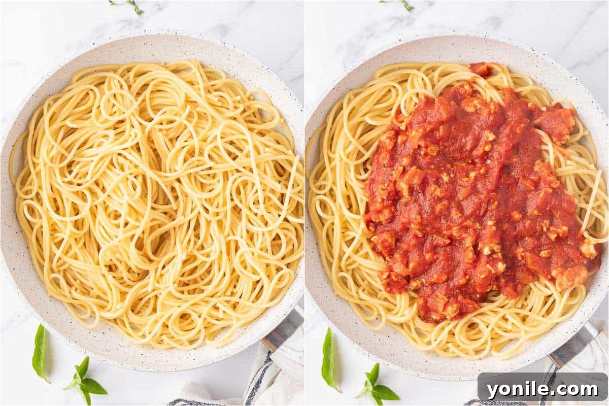 Combining freshly cooked spaghetti noodles with the healthy chicken bolognese sauce in a wide pan.