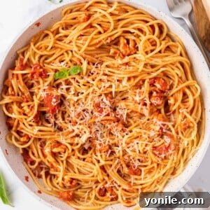 Ground chicken bolognese topped with parmesan cheese, showcasing its rich texture and vibrant colors.
