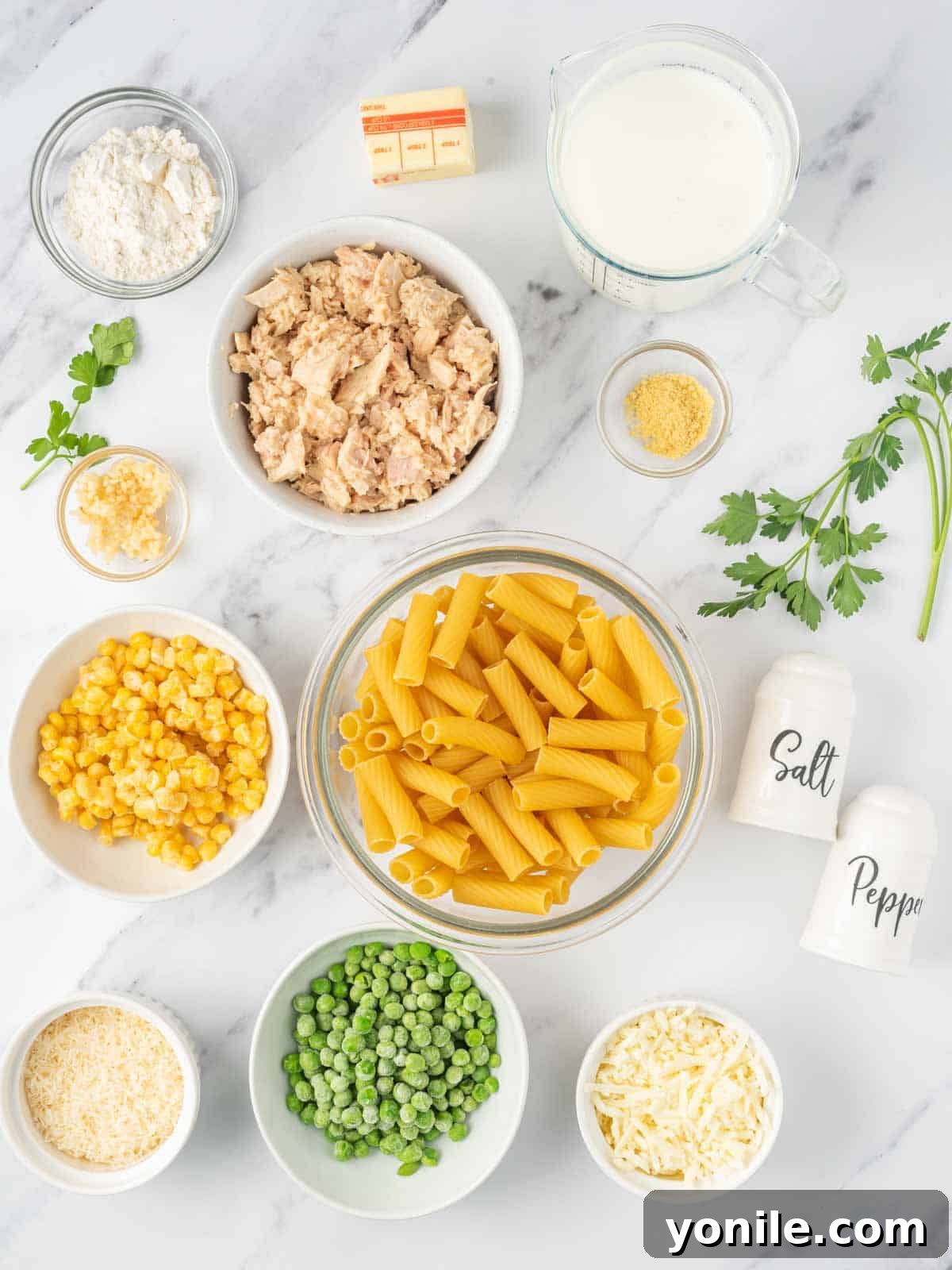 Velvety Tuna Pasta Casserole 3 Ingredients needed for creamy tuna pasta bake, including pasta, tuna, peas, corn, and cheese.