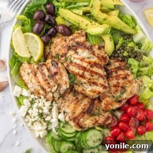 Vibrant Greek Grilled Chicken Salad 9 Greek chicken salad recipe on a platter with dressing on the side.