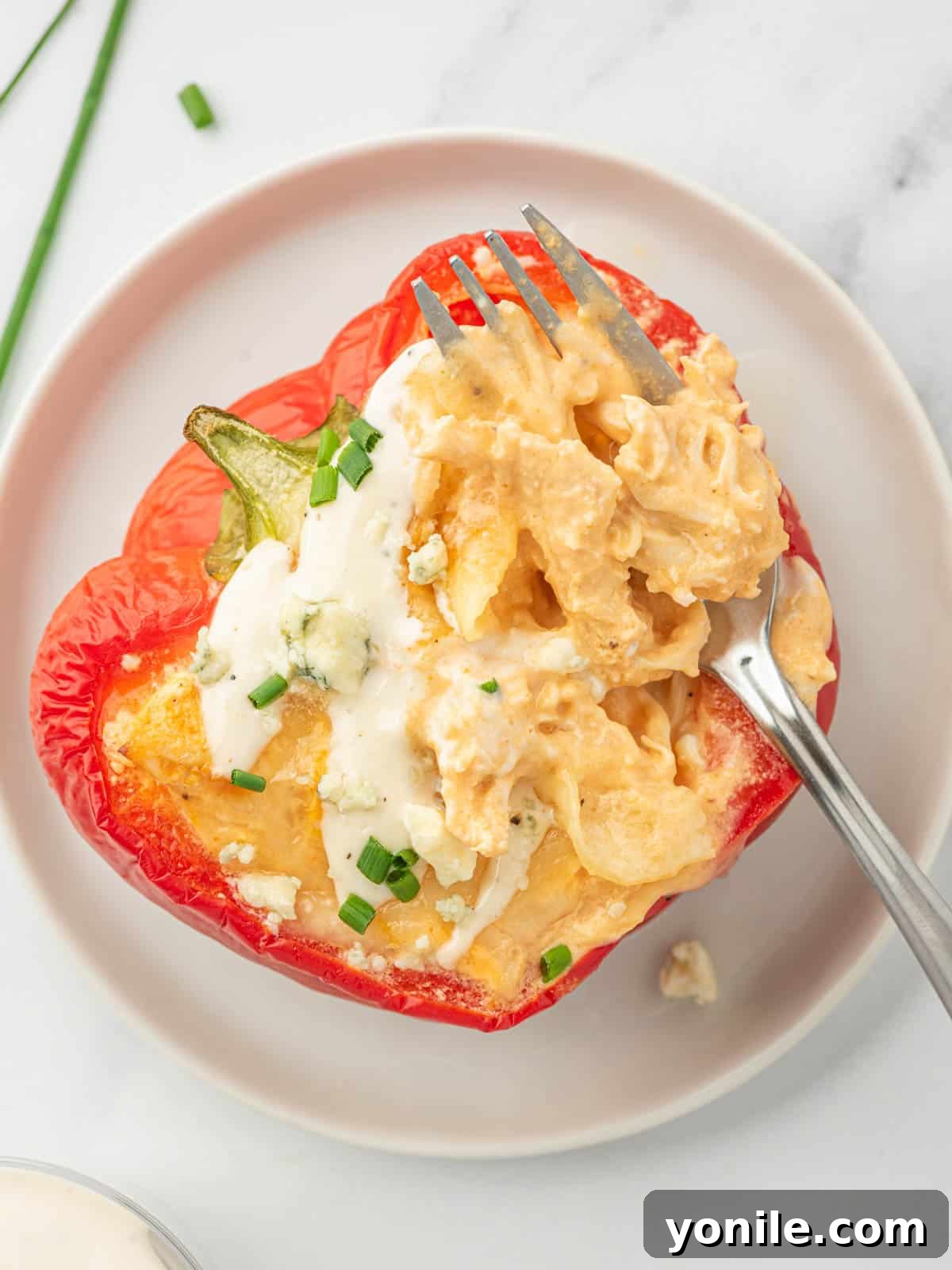 Stuffed buffalo chicken pepper on a plate with a fork.