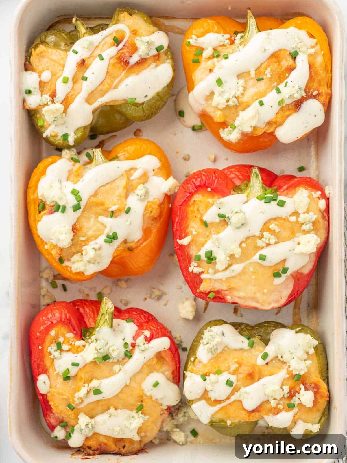 A tray of keto stuffed peppers with chicken and blue cheese crumbles.
