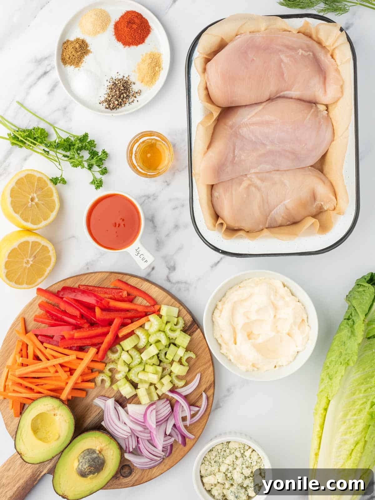 A selection of fresh ingredients laid out for easy buffalo chicken salad preparation.