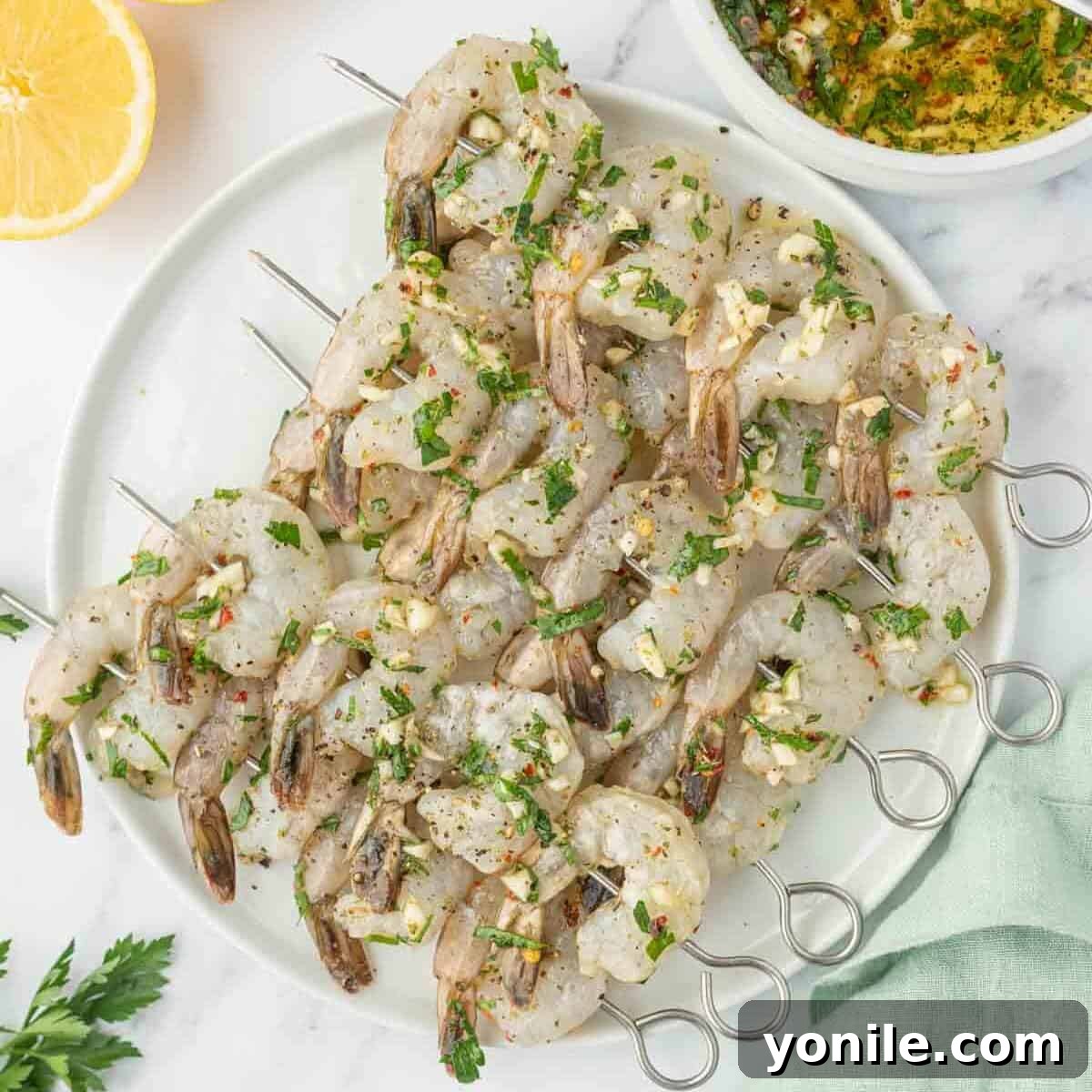 Marinated garlic shrimp threaded neatly onto wooden skewers, ready for the grill.