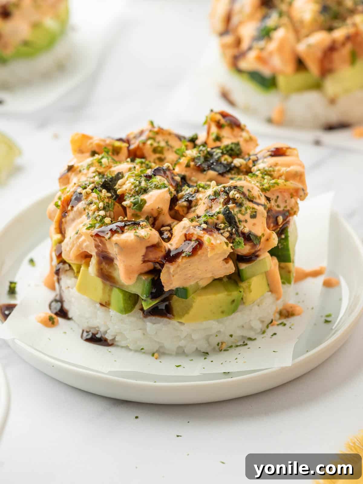 Shrimp Sushi Tower 2 Closeup shot of a homemade shrimp sushi stack on a plate, garnished with furikake.