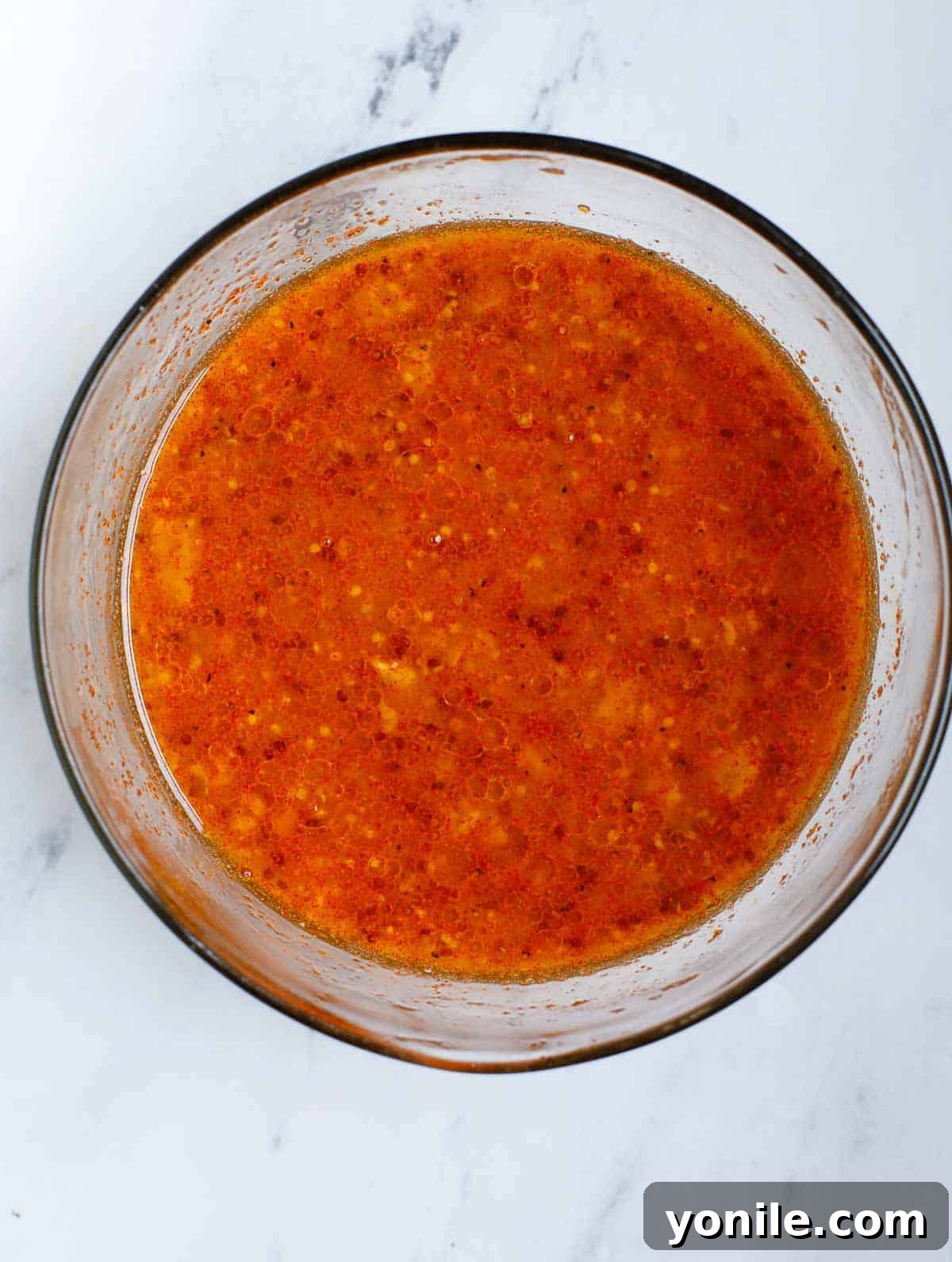 Close-up of a bowl containing the Dijon mustard marinade and sauce for salmon fillets, ready to be applied.