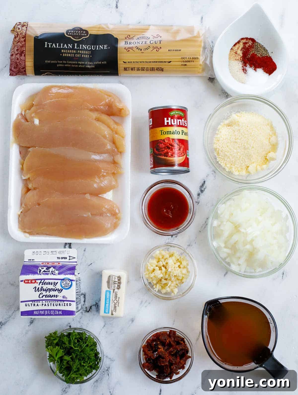 Ingredients needed for creamy spicy chicken pasta, including pasta, chicken, fresh herbs, and various sauces.