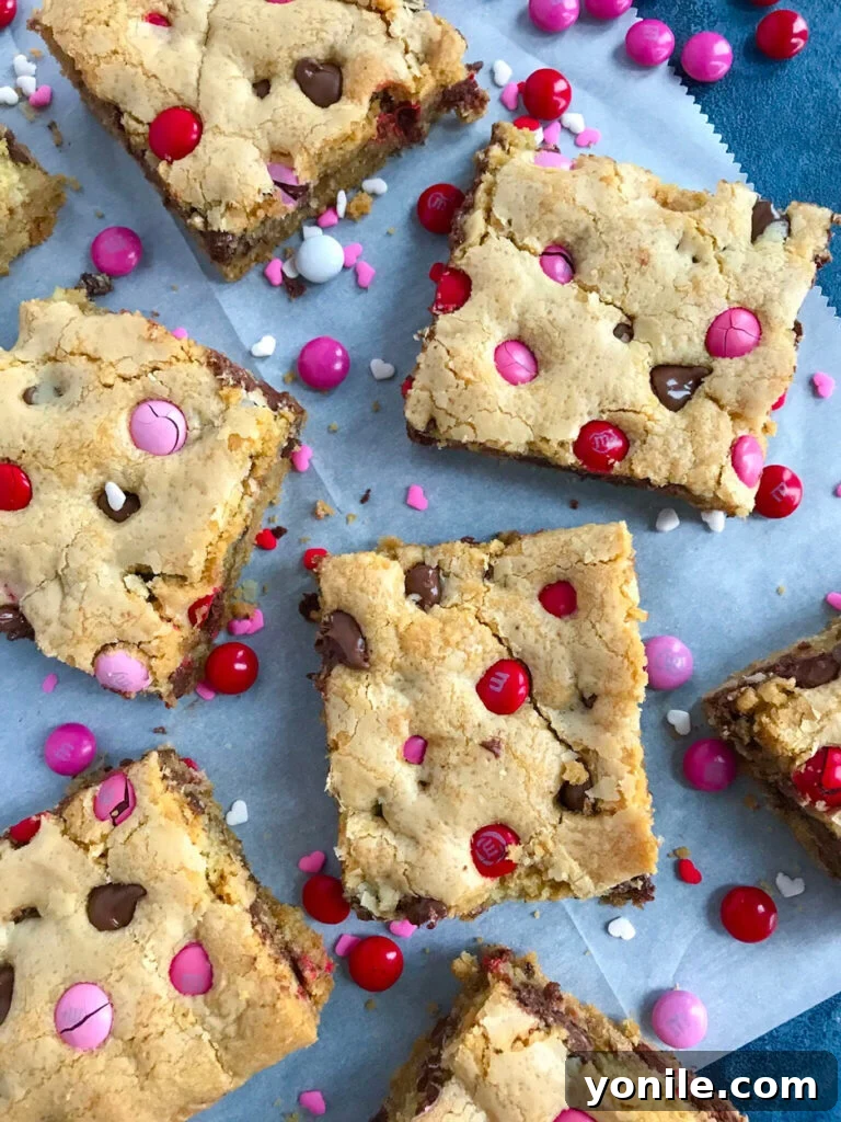 Freshly baked Valentine's M&M Chocolate Chip Cookie Bars cooling on a wire rack.