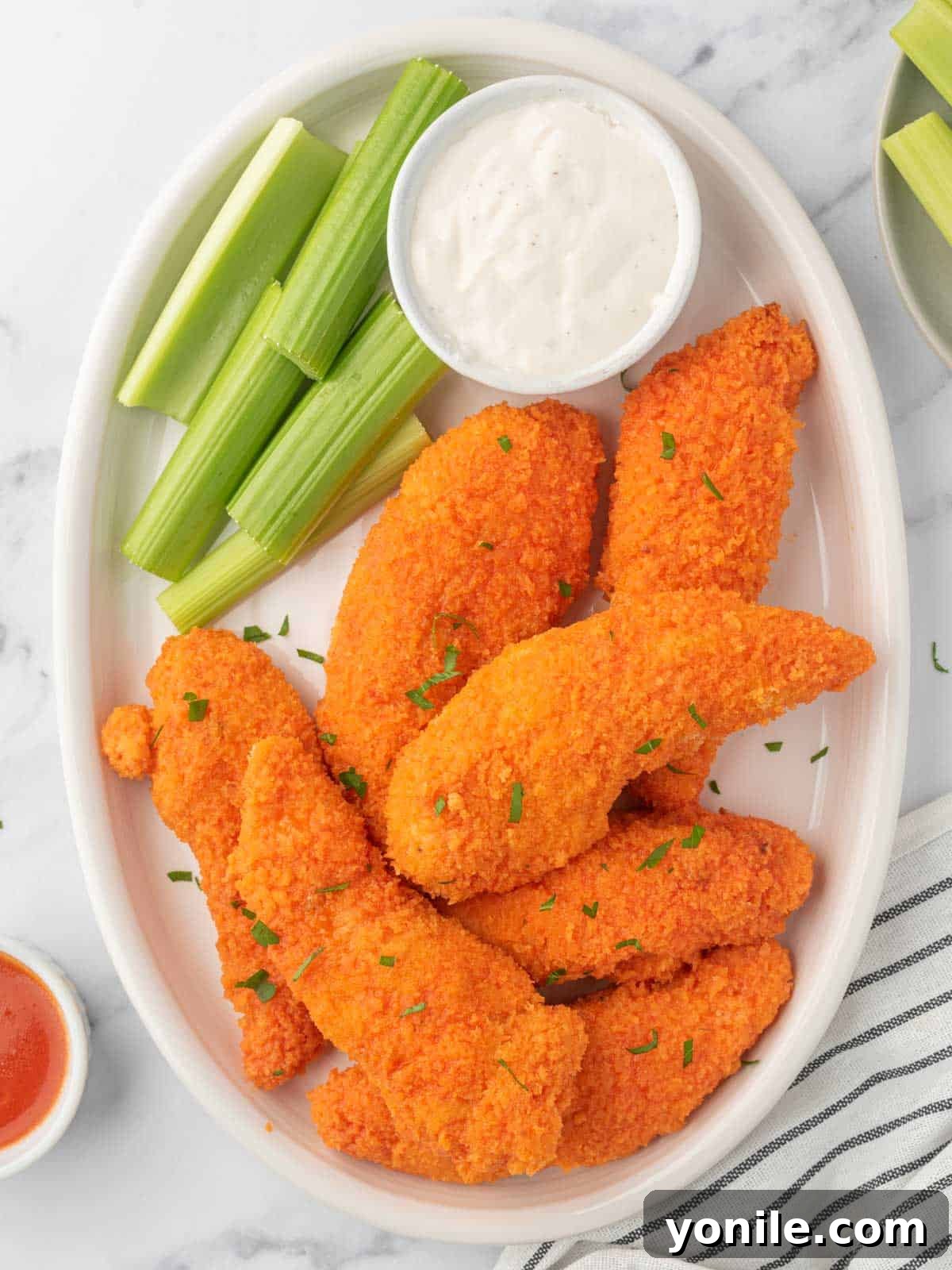 Oven-Crisped Buffalo Tenders 2 A plate of crispy buffalo chicken strips, perfectly golden and ready to serve.