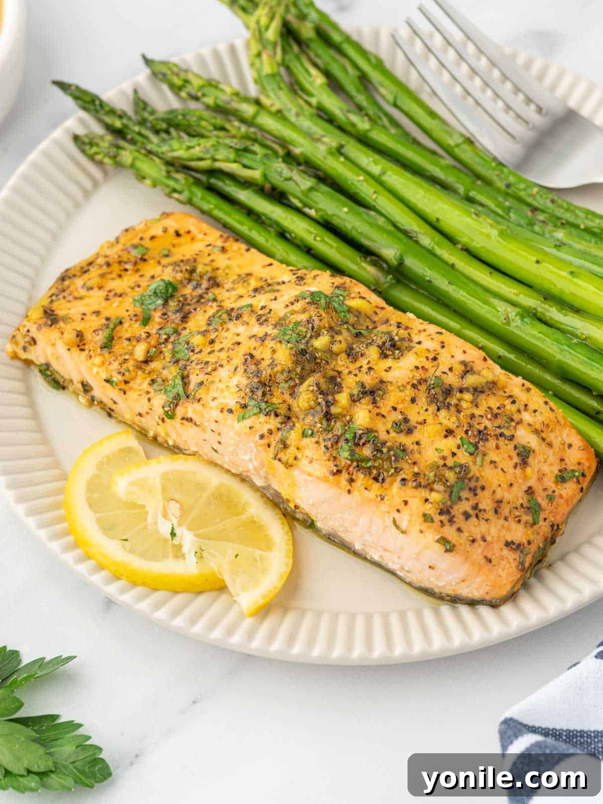 A plate with baked lemon pepper salmon and asparagus.