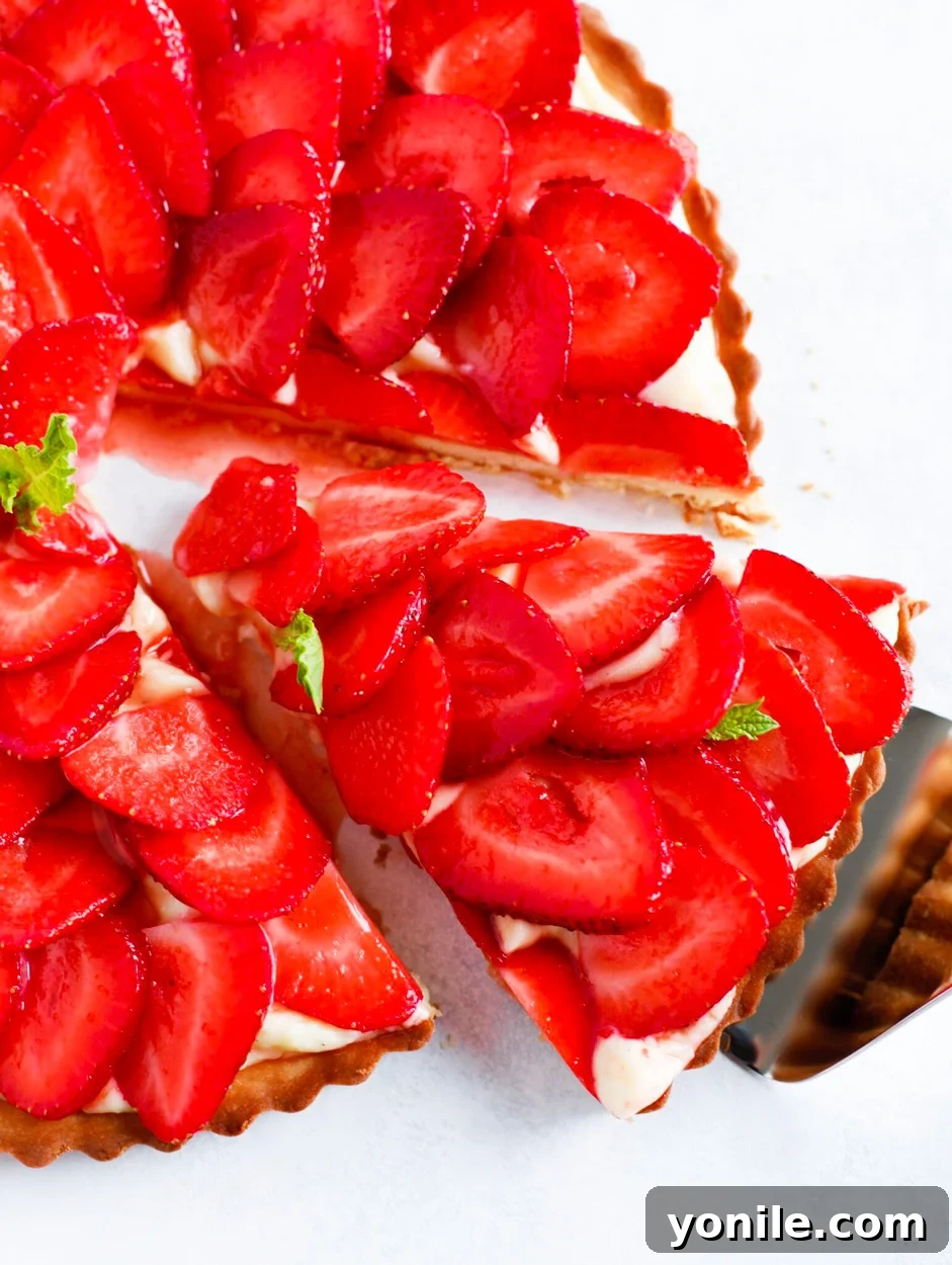 Strawberry French Tarte with a slice being taken out.