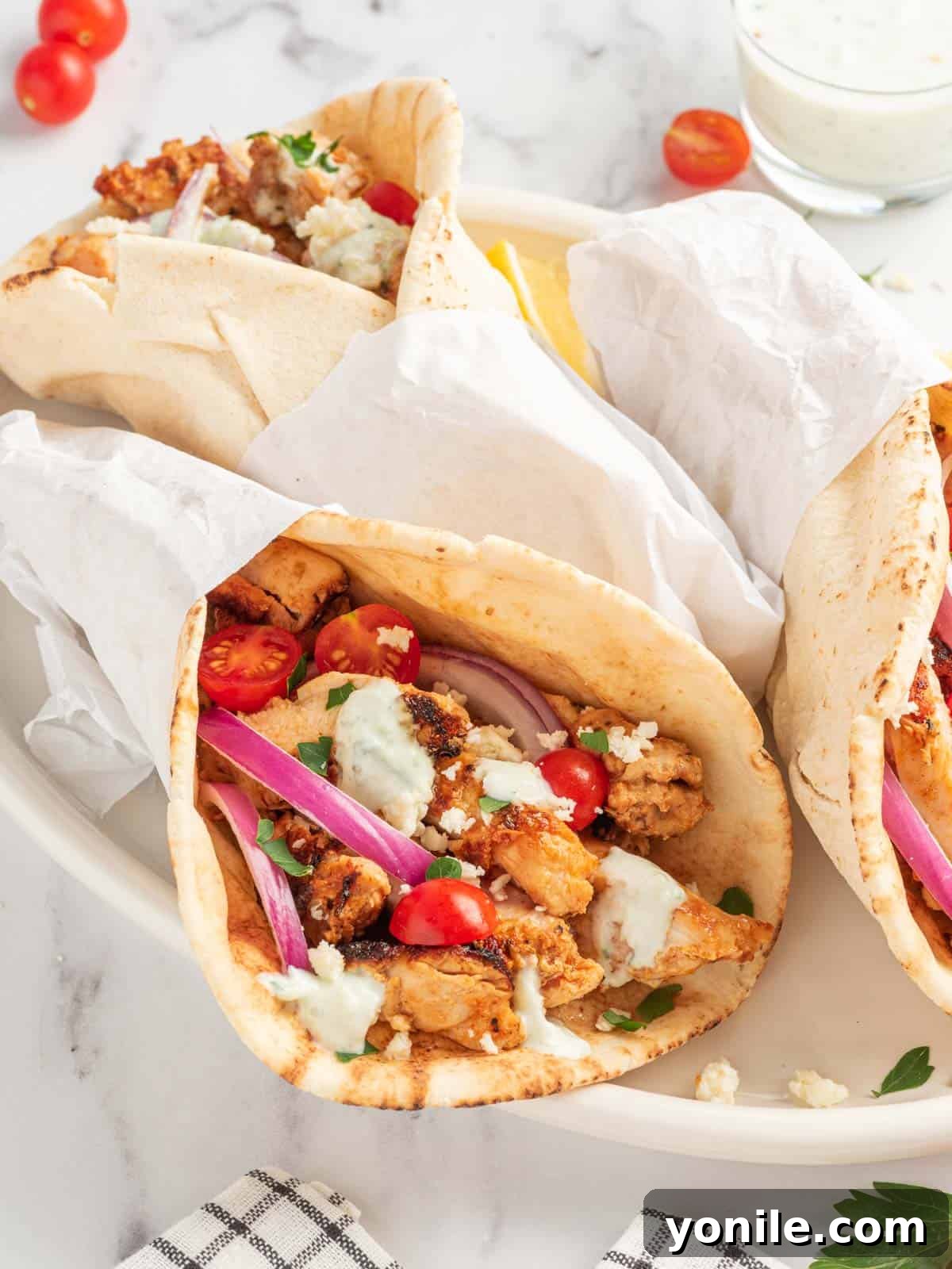 Authentic Homemade Greek Chicken Gyros 7 A vibrant platter of authentic chicken gyros, garnished with fresh herbs and colorful vegetables, inviting diners to enjoy.