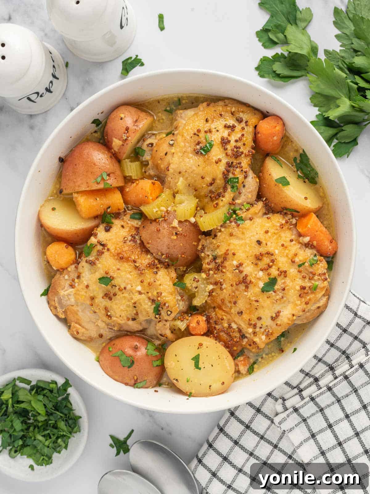 A vibrant bowl of Instant Pot Honey Mustard Chicken Stew, showcasing juicy chicken thighs, tender potatoes, and carrots in a rich sauce.