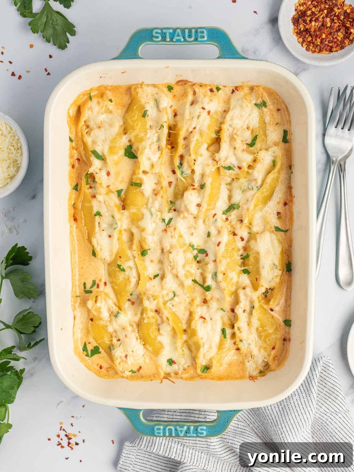 Spicy Cajun Chicken Alfredo Stuffed Pasta Shells 2 A baking dish filled with creamy Cajun Chicken Alfredo Stuffed Shells, garnished and ready to serve.
