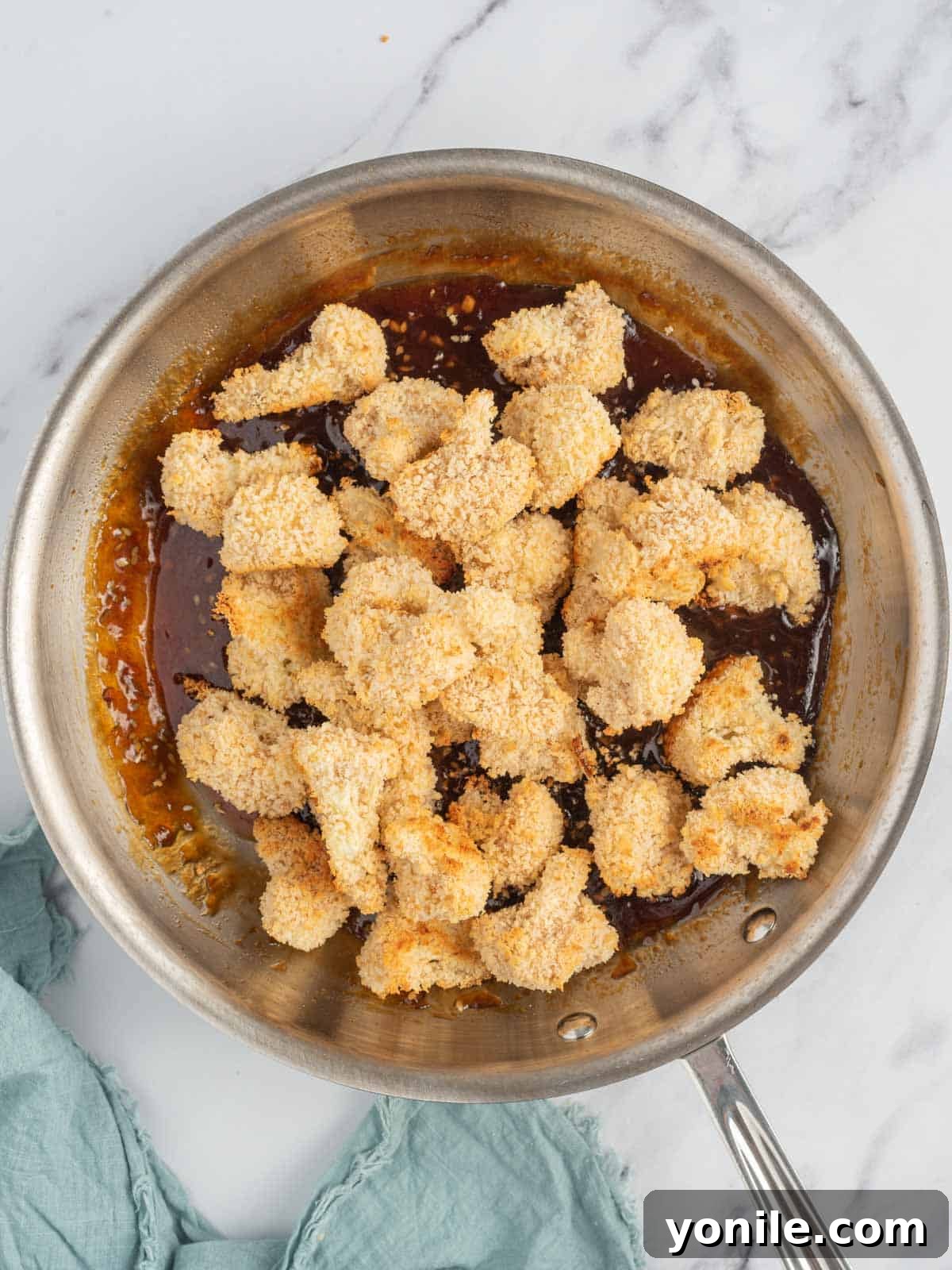Baked cauliflower bites are tossed with asian sesame sauce.