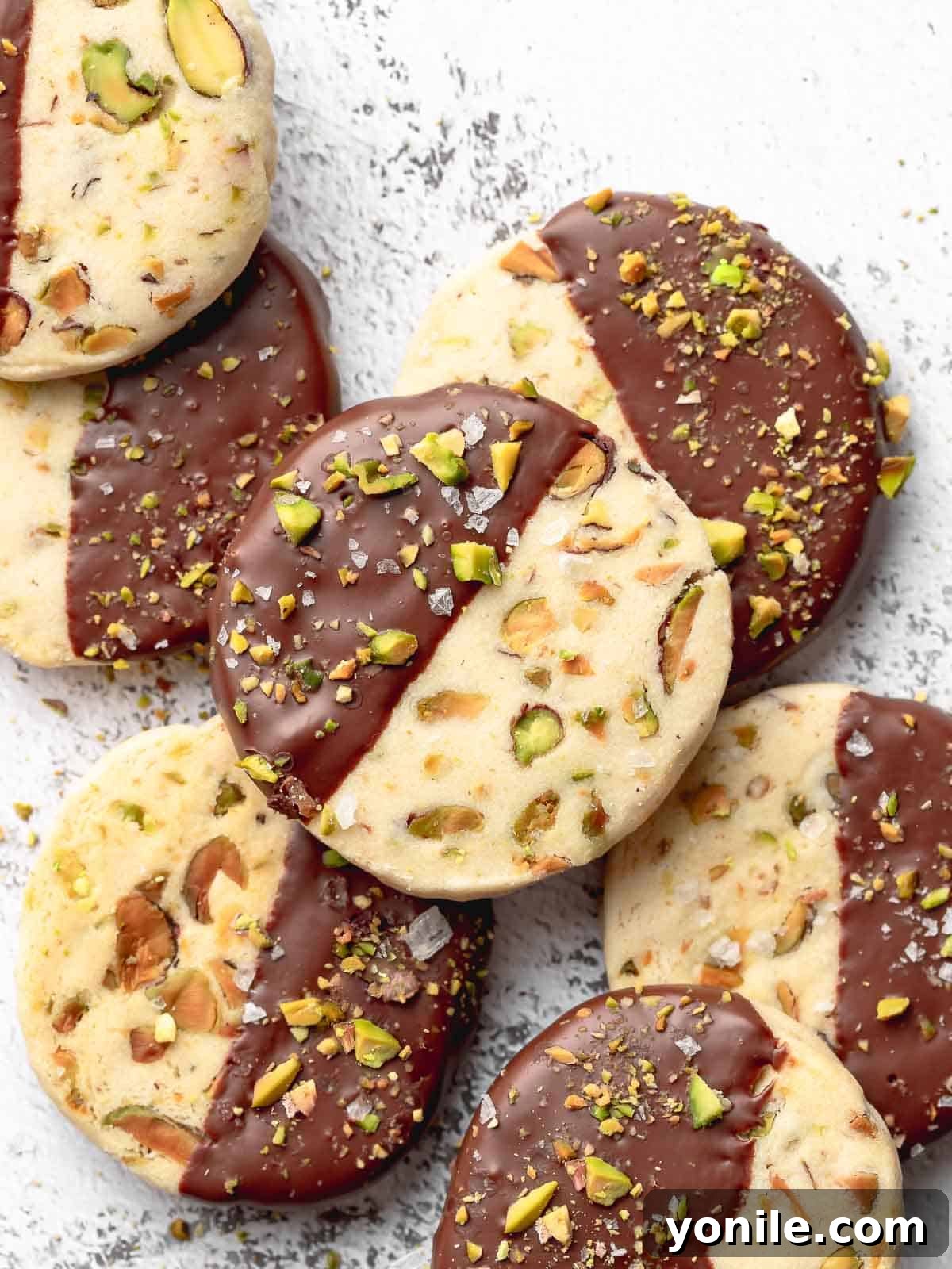 Buttery Pistachio Shortbread Delights 8 A stunning plate of freshly baked pistachio shortbread cookies, artfully dipped in chocolate and garnished, ready to be enjoyed.